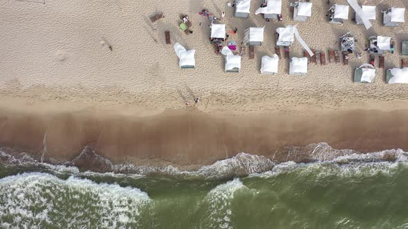 AERIAL: Top Shot of White Tents on Sandy Beach on a Sunny Windy Day