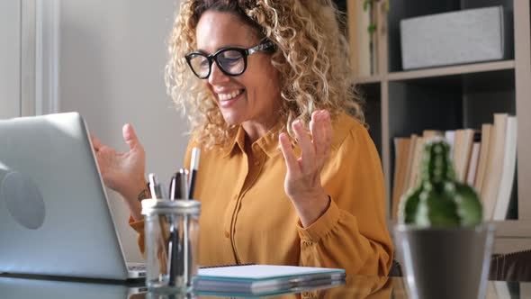 Smiling businesswoman using laptop at home office alt