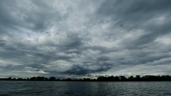 Time Lapse View of the River and the Clouds Running Above It Before the Rain, Dark Blue and the