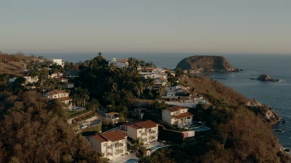 Winter sunset on pacific coastline. Hotels and villas near rocky beaches