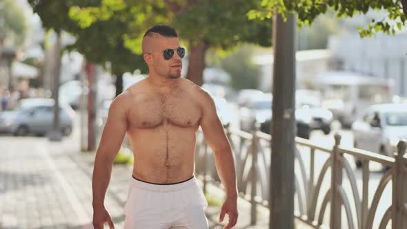 A Muscular Jordanian Man Walks Around the City Without a Shirt alt