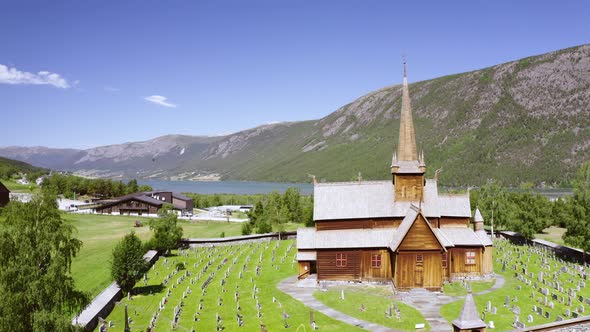 Stunning View Of Lom Stave Church (Lom Stavkyrkje) In Oppland, Norway. - Aerial Wide Shot alt