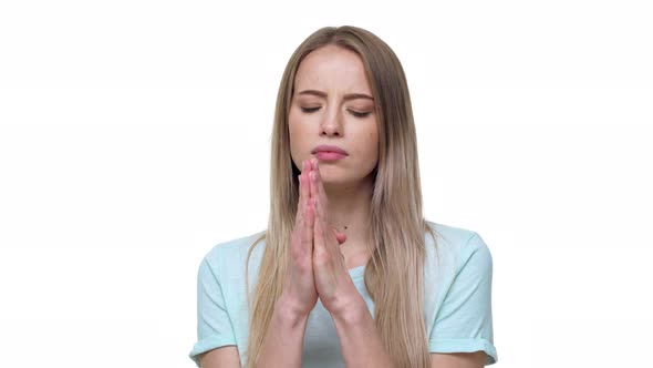 Portrait of Woman Looking Up with Keeping Hands in Praying Pose and Expressing Hope and Desire alt
