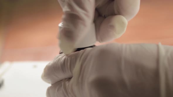 Opening bottle of medication with hygiene gloves close up shot alt