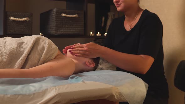 A Woman Enjoys a Pleasant Facial Massage