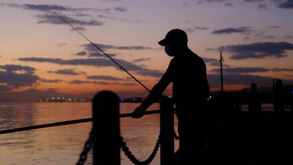 Reddish Silhouette of Man Fishing in Air alt