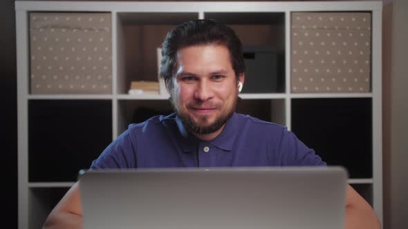 Smiling young man talk with friends make live video conference call online chat using laptop at home alt