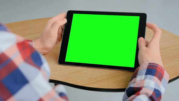 Chroma Key Concept - Man Looking at Tablet Computer with Green Screen