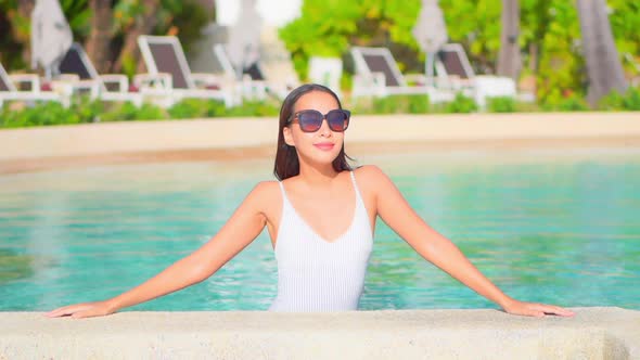 Young asian woman enjoy around outdoor swimming pool for leisure