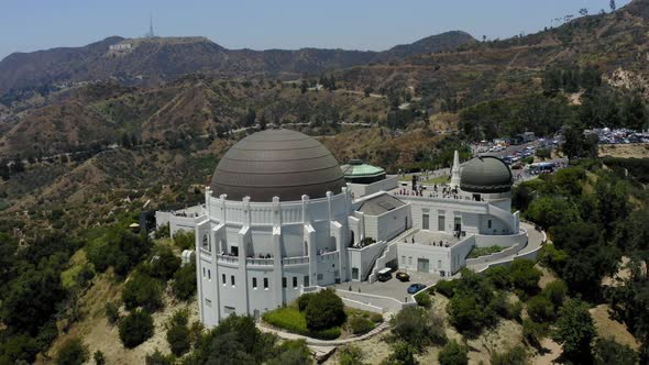 Aerial video orbiting the Griffith Observatory with the Hollywood sign in the background alt