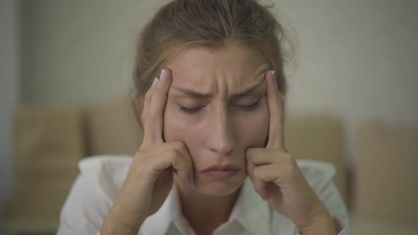 Close-up Face of Tired Caucasian Woman Rubbing Temples. Portrait of Exhausted Young Lady Having alt