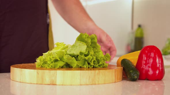 Man Tearing Lettuce in Kitchen