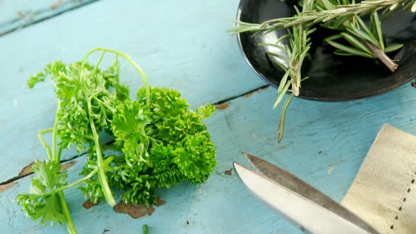 Various herbs, scissors and napkin on wooden table 4k alt