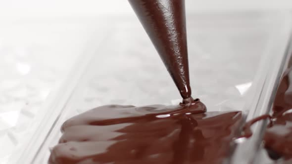 Close-up Pouring Dark Chocolate Into Bar-shaped Designed Mold, Slow Motion