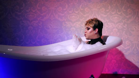 Transsexual take bath in neon light. Woman. Cosmetic foam bisexual trans. People alt