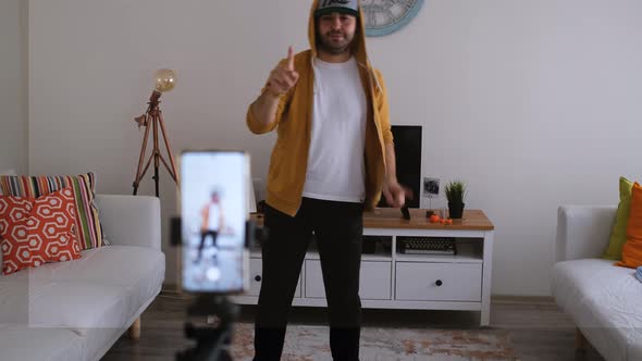 Young man is recording dance training video on social media on his phone