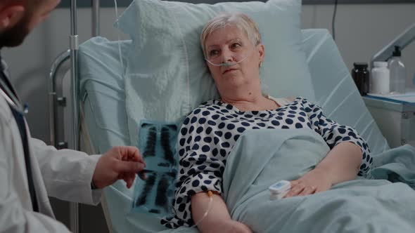 Medic Explaining x Ray Scan Results to Senior Patient alt