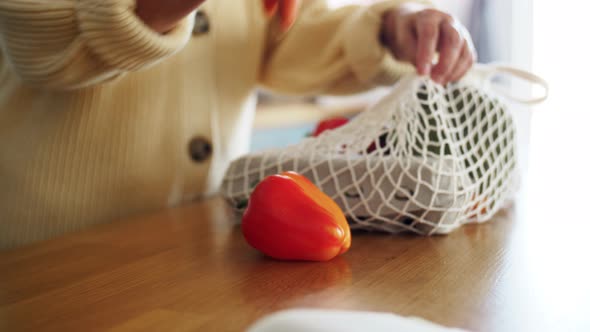 Woman with Vegetables in String Bag on Kitchen