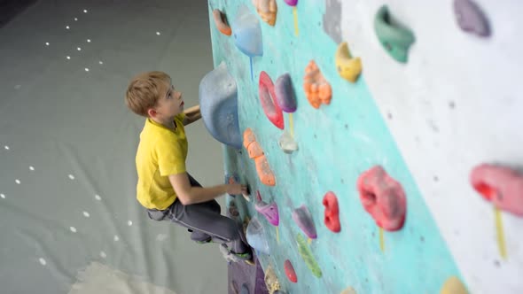Caucasian Teenager Climbing Wall at Gym alt