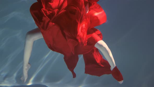 Attractive Redhaired Young Woman Swims Beautifully Underwater in a Red Dress alt