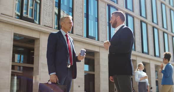 Successful Businessmen Discussing Work Outside Office Drinking Coffee Togo in Morning alt