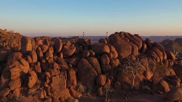 Aerial view of two person standing on the cliff top in Damaraland, Namibia. alt