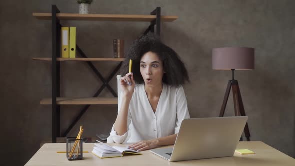 Got an Idea. Beautiful Freelance Curly African American Girl Lifts Up a Pencil alt