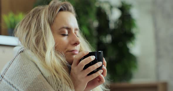 Close Up of Sick Woman Sitting at Home in Blanket with Hot Tea Suffering From Fever Temperature alt