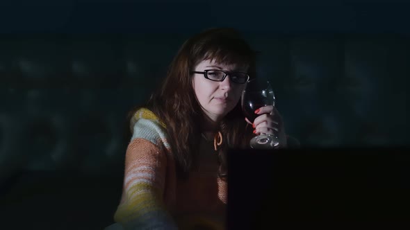 Sad Woman with a Glass of Wine Near the Tv in the Evening at Home Thinking Depression Cinematic Shot
