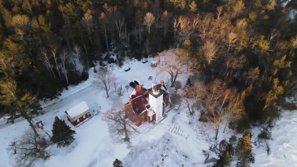 4k drone video of 40 Mile Point Lighthouse in Presque Isle County in Michigan during the winter. alt