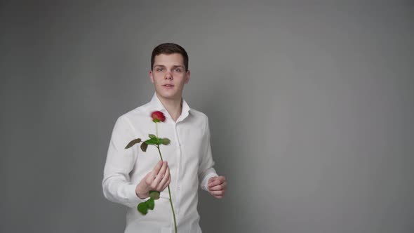 A Young Handsome Guy Offers a Red Rose