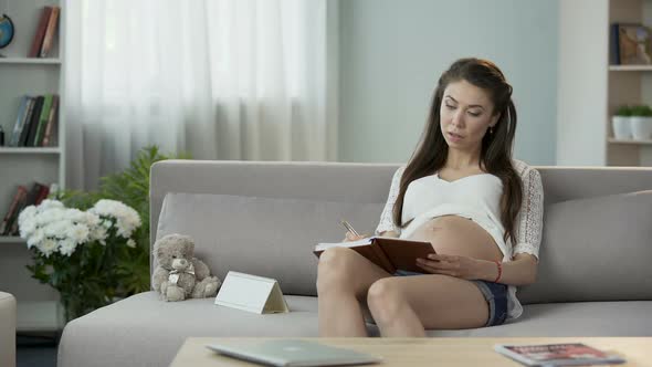 Future Mother Counting Days on Calendar, Taking Notes in Notebook, Planning alt