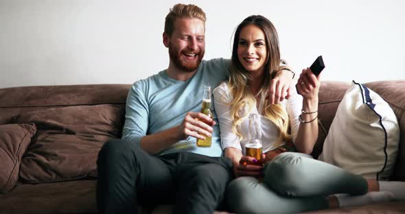 Beautiful Couple in Love Watching Tv and Drinking