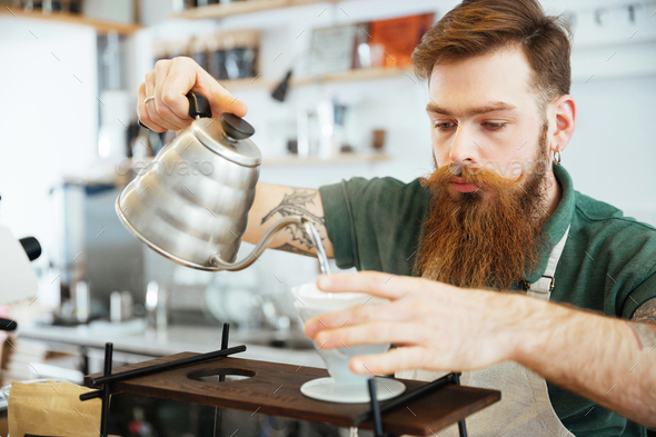 Barista pours ground coffee to aeropress Stock Photo by bublikhaus