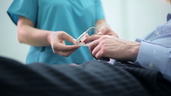 Nurse Puts a Pulse Oximeter on Finger alt