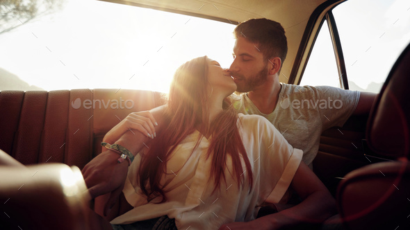 Couple on road trip sharing a romantic kiss