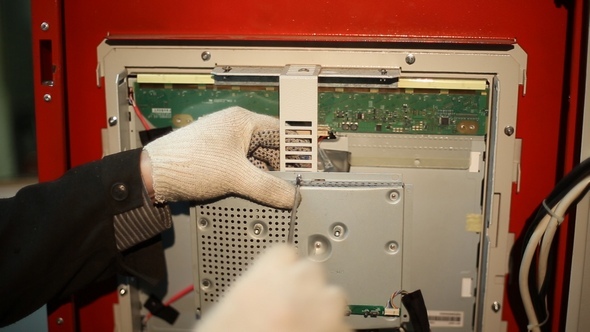 The Scientist Twists the Screws Using Screwdriver in the Switchboard alt