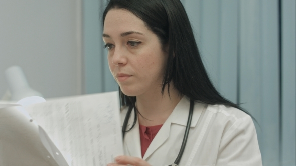 Female Doctor In Medical Office Analyzes Results An Electrocardiogram And Takes Notes alt