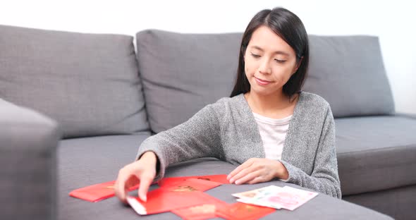 Woman Putting Money Into Chinese Red Packet alt