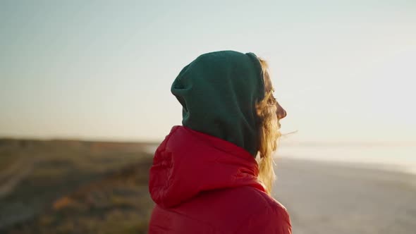 Slow Motion Close Up Portrait of Young Adult Woman Traveler Looking at Sunrise at Sea Beach alt