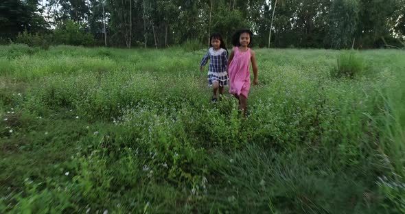 4K Two little girls running around the park alt