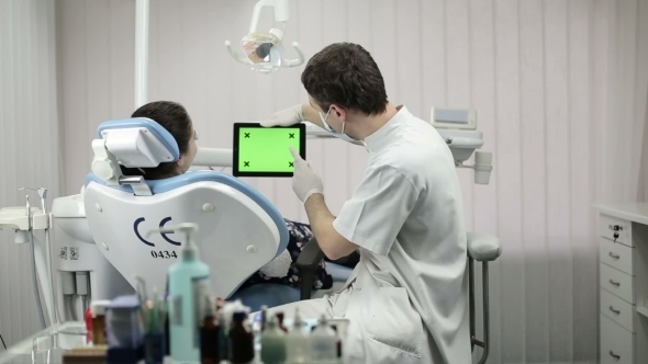 Dentist Explaining Procedure To Female Patient In Dentist Room alt