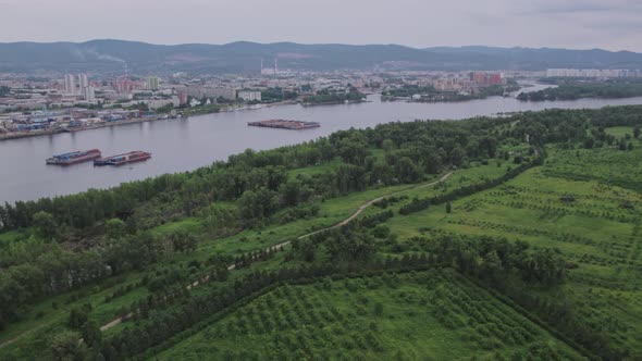 Flight Over the Park with a View of the Barges and the City alt