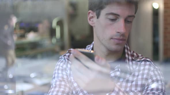 CU TU Man drinking coffee and using mobile phone in cafe / London, Greater London, United Kingdom.