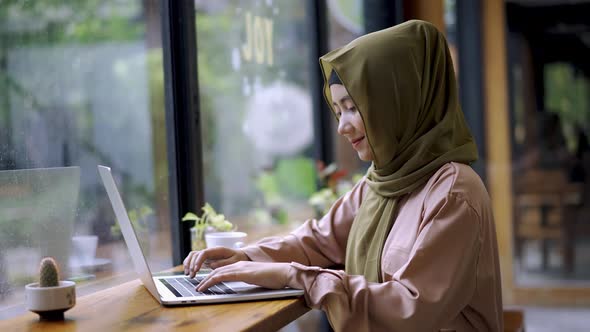 Young Asian Muslim Woman Working in the Coffeeshop 02