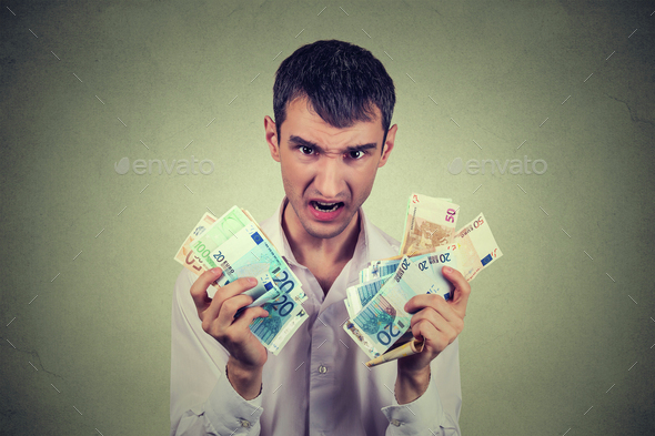 Greedy man with euro banknotes bills isolated on gray wall background