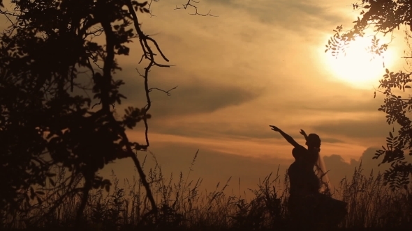 Silhouette Of Married Couple Dancing In The Field