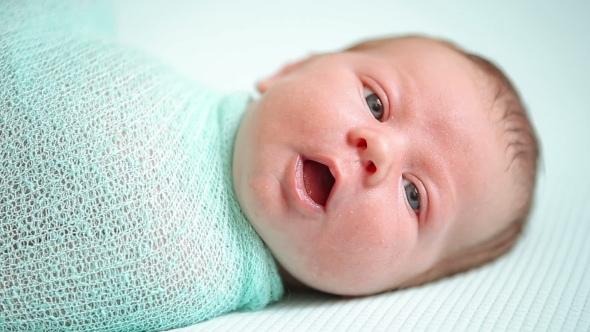 Blue Eyed Newborn Baby Lying And Looking Around In Wonder alt