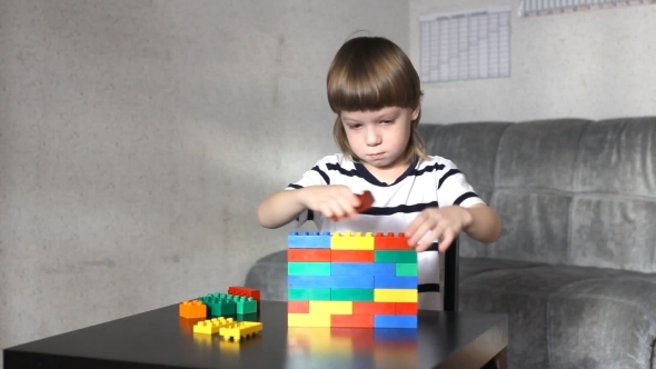 Boy Playing With Lots Of Colorful Plastic Blocks Indoor