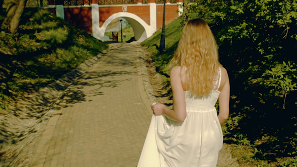 Young Woman Walking in White Dress